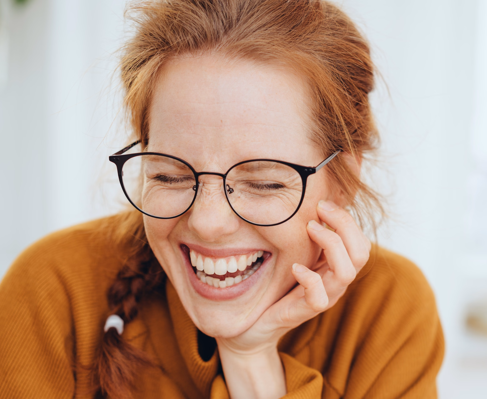 Lachende Frau mit Brille und roten Haaren